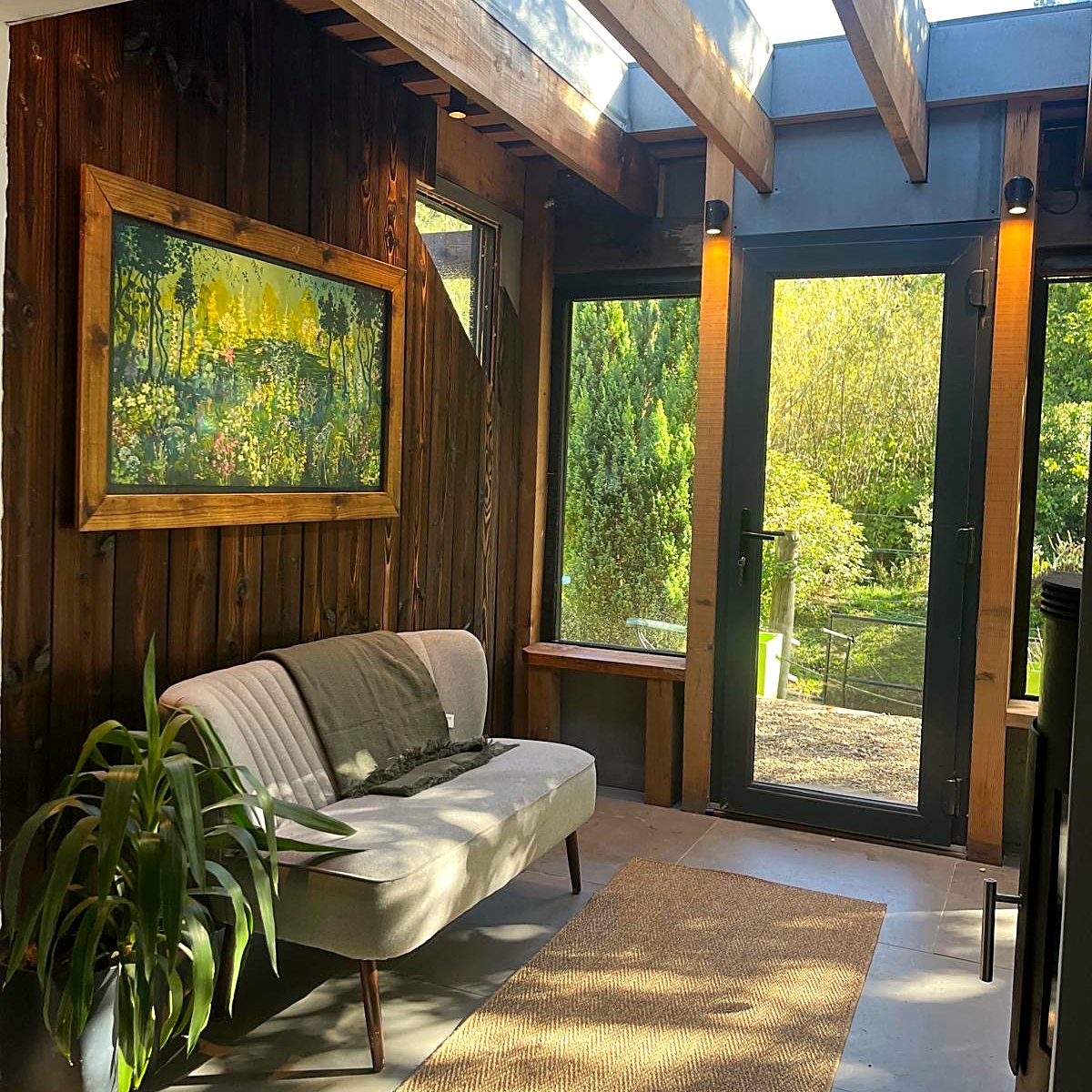 The Forest of Dreams hanging on the timber wall of the Zero-Zero Treehouse lobby, beside glass doors opening onto the woods