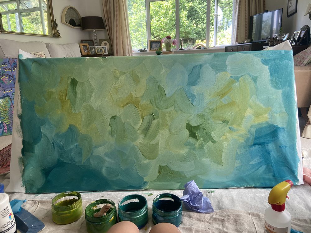 The blank canvas covered in loose washes of blue and yellow
