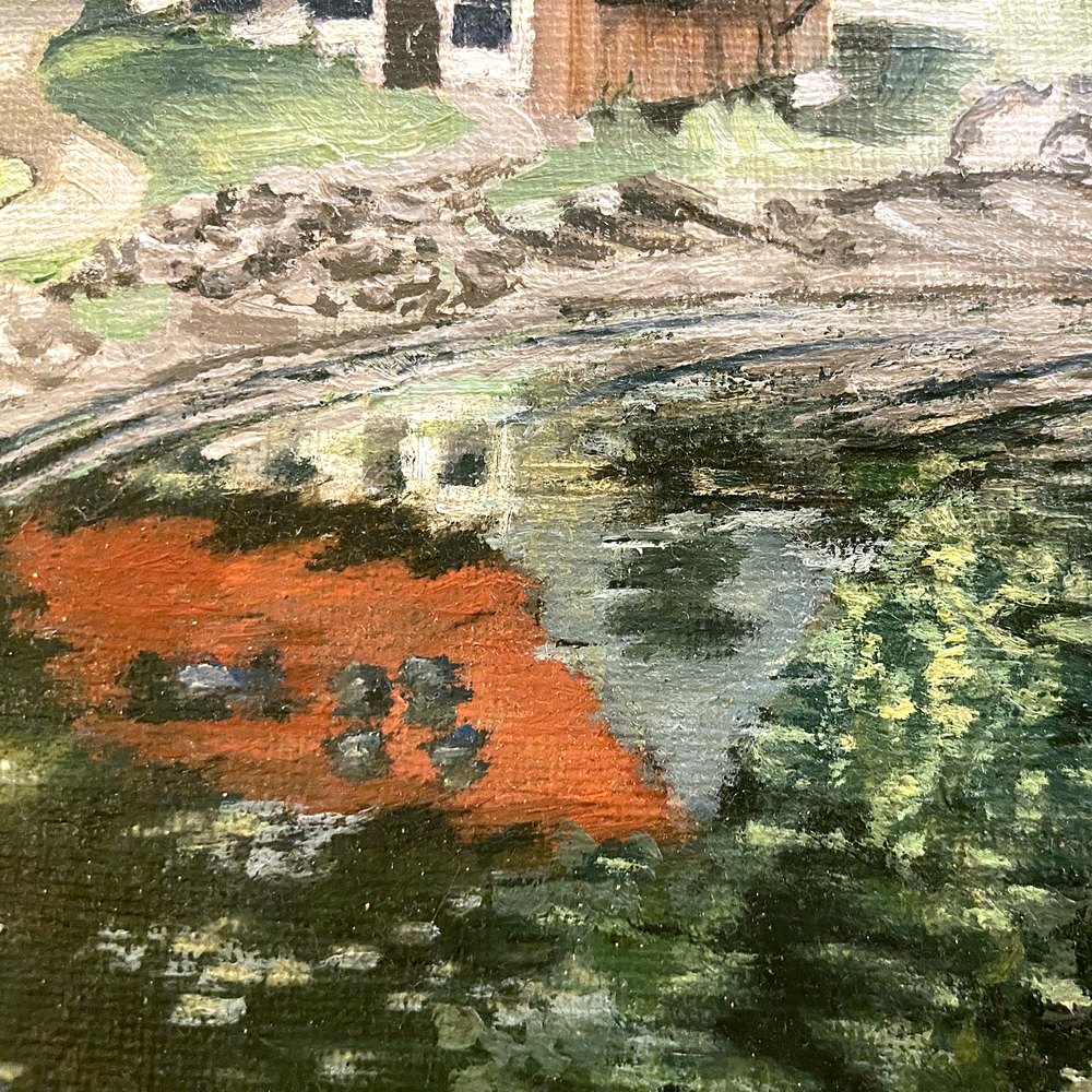 Close-up of the boat house's red roof reflected in the dark green water